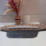 La serviette menstruelle lavable à pois est présentée en coupe, non cousue. On distingue le côté motif en coton, les deux épaisseurs de tissu éponge absorbant et la face imperméable grise.