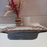 La serviette menstruelle lavable à pois est présentée en coupe, non cousue. On distingue le côté motif en coton, une épaisseur de tissu éponge absorbant et la face imperméable grise.