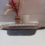 La serviette menstruelle lavable à pois est présentée en coupe, non cousue, pour montrer sa composition. On distingue le côté motif en coton, les trois épaisseurs de tissu éponge absorbant et la face imperméable grise.